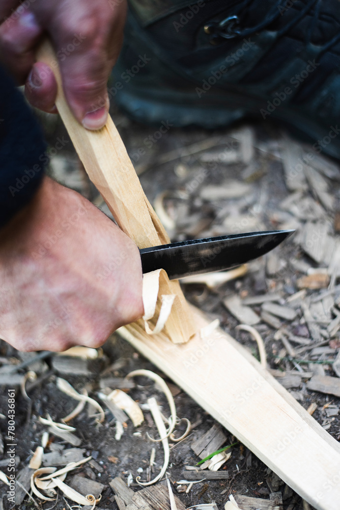 Cropped hands of man carving stick in forest Cropped hands of man carving stick in forest