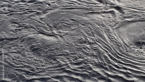 flowing water with chaotic patterns, eddy whirlpools and ripples