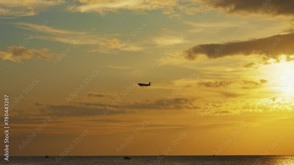 Silhouette of Commercial Passenger Plane Flying at Sunset Against Golden Sky and Bright Sunlight Over the Ocean. Gorgeous Sunset Sky. Tropical Vacation Concept Silhouette of Commercial Passenger Plane Flying at Sunset Against Golden Sky and Bright Sunlight Over the Ocean. Gorgeous Sunset Sky. Tropical Vacation Concept