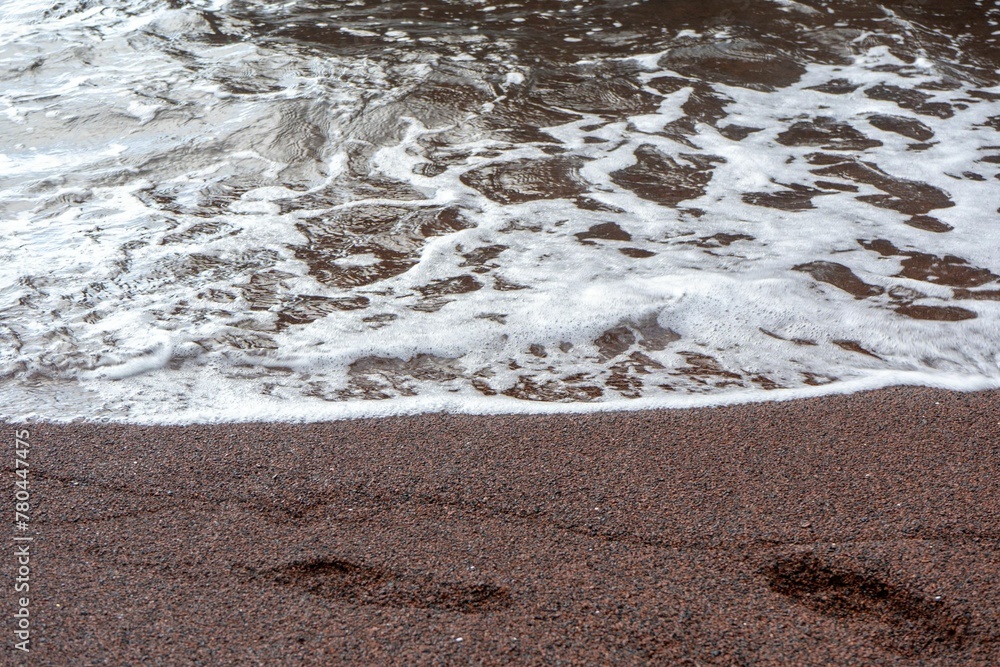 Foamy water rolling into a sandy shore. Foamy water rolling into a sandy shore.