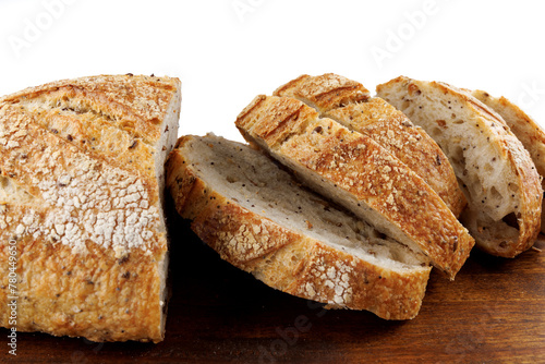 Cut loaf with seeds on a wooden board on a white background. Sliced pieces of bread. Art bread.