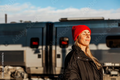 Woman wearing knit hat with eyes closed on sunny day