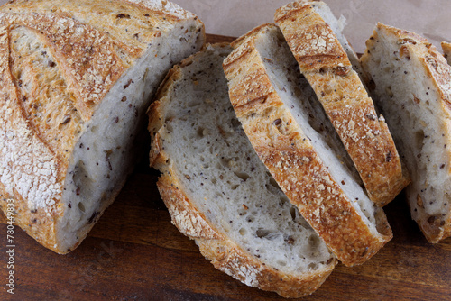 Cut loaf with seeds on a wooden board. Sliced pieces of bread. Art bread.