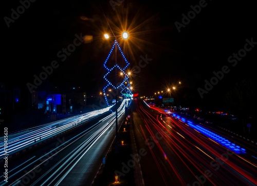 Long exposure shot of the road at night with lights of cars in the dark