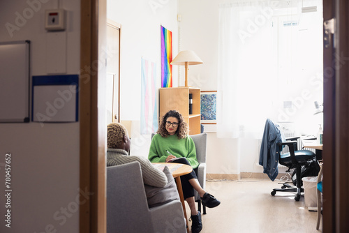 Female therapist sitting in office and listening patient photo