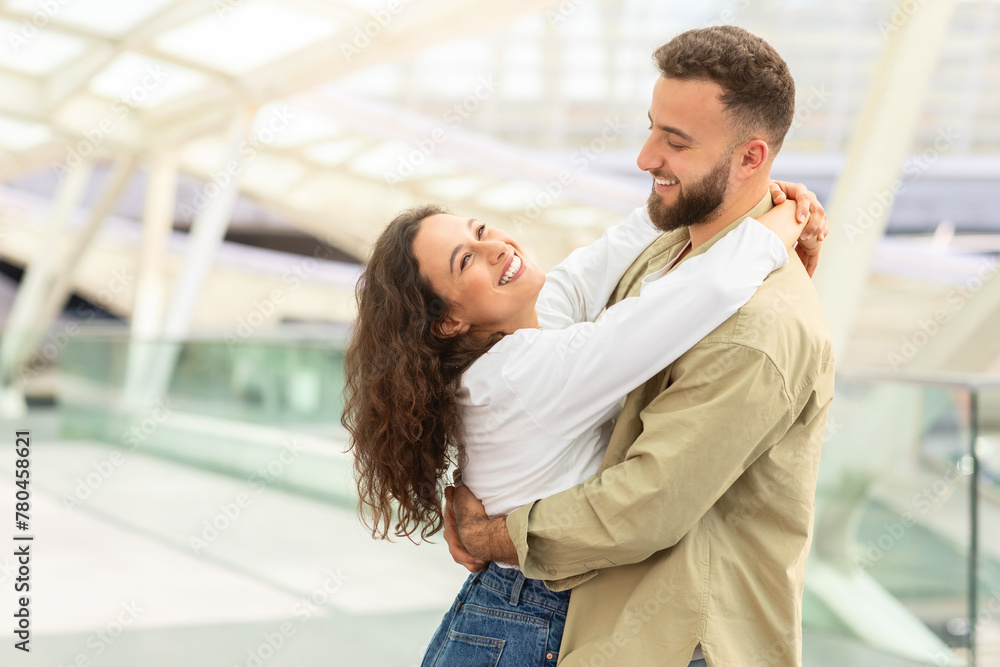 Joyful Couple Embracing at Modern Airport Terminal
