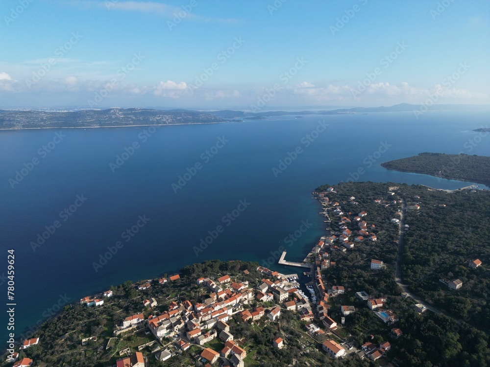 Aerial view of a town at the forested coastline on a sunny day