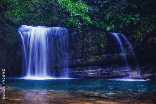 Scenic view of a small waterfall over a rocky forest ledge in Taiwan