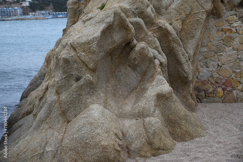 Photo of a huge stone with a cavity on the shores of the sea