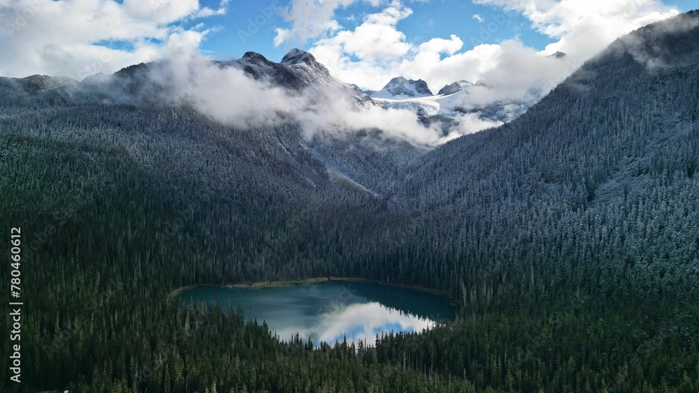 View of a round lake surrounded by trees in the mountains in Joffre Lakes Provincial Park