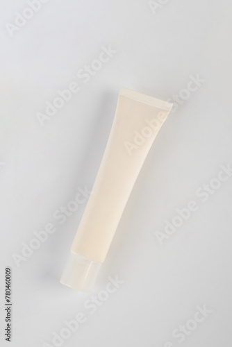 Plastic white tube for cream or lotion. Skin care or sunscreen cosmetic on pink background.