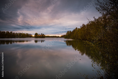 Beautiful sunset over the lake surrounded by trees which reflect in the water in Bavaria  Germany