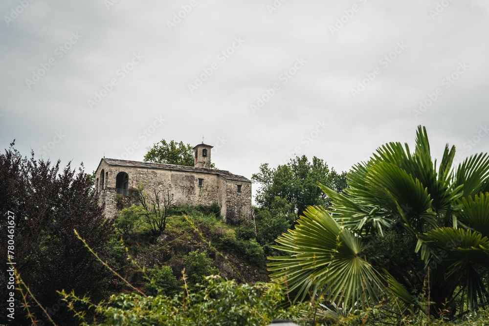 Stone building on the top of a mountain surrounded by forest on a cloudy day