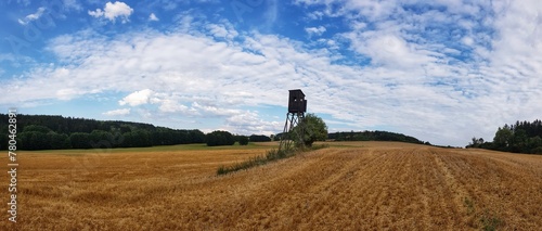 Scenic view of a wooden viewpoint in an open field on a sunny day