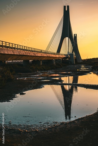 Vertical shot of a beautiful bridge near the sea at sunset