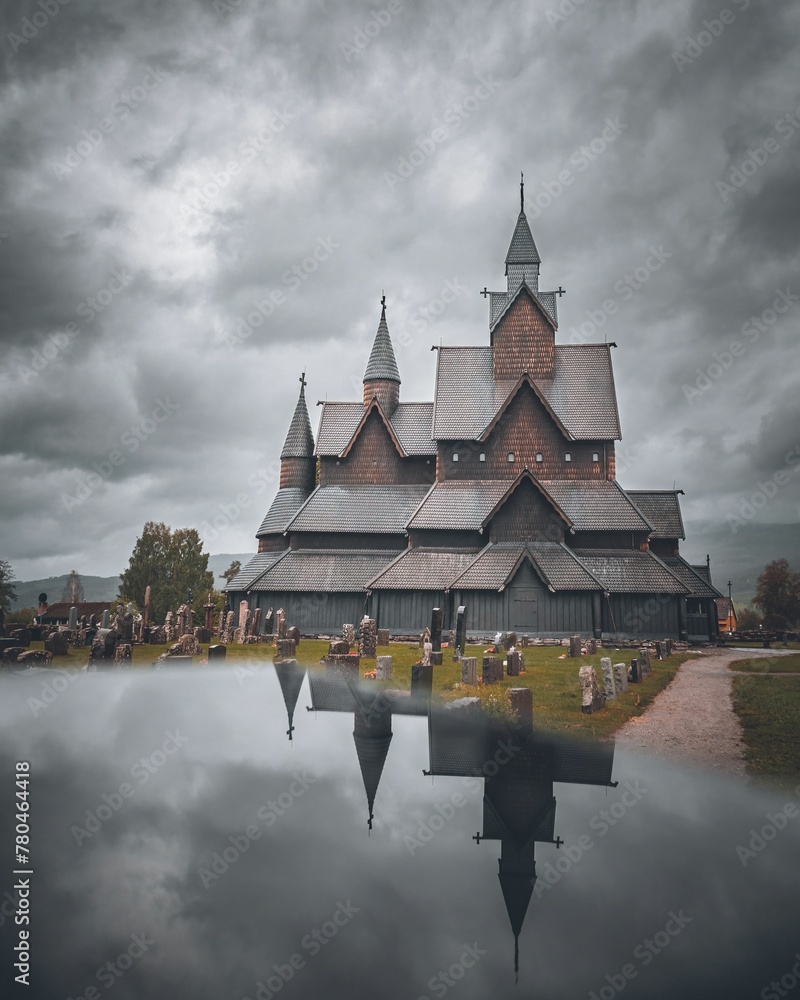 Obraz premium Heddal stave church, an old Scandinavian Viking building, and its reflection in Norway, vertical