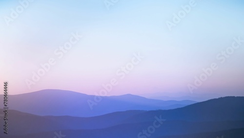 Layers of dreamy silhouette of the mountain range between sunset and blue hour © Wirestock