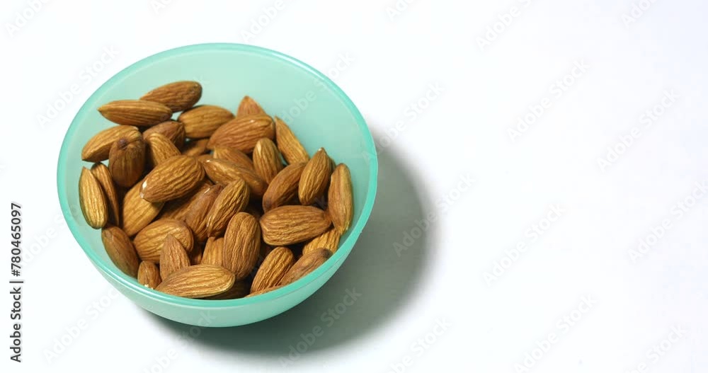 Timelapse closeup shot of a couple eating a healthy snack of raw almonds nuts on a white background. Timelapse closeup shot of a couple eating a healthy snack of raw almonds nuts on a white background.