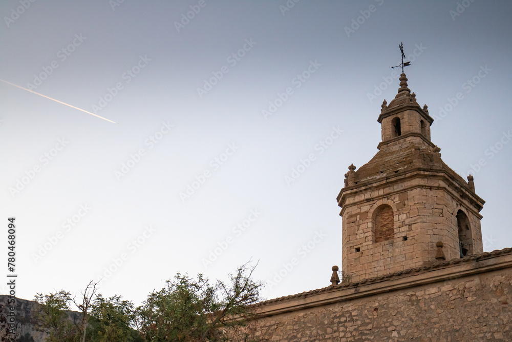 church tower in evening sunset and plane line, navarra, spain