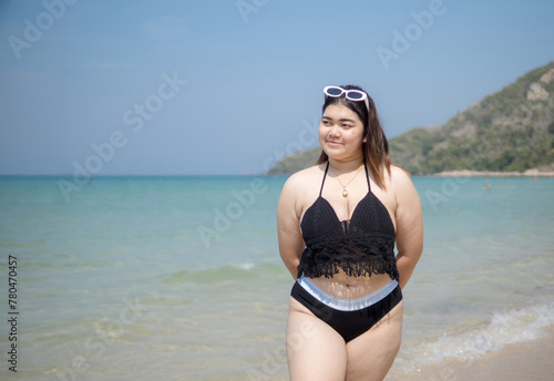 Portrait young asian woman fat chubby cute beautiful smile happy fun enjoy relax bikini swimwear body sexy front view sea beach white sand clean bluesky calm nature ocean wave water travel on holiday © Singh