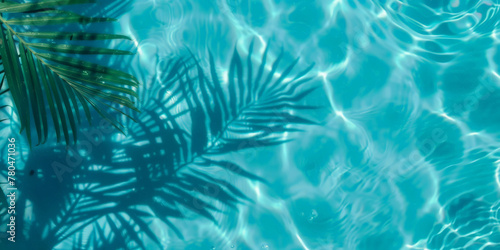A closeup of blue water swimming pool with palm leaves shadows . creating a beautiful summer scene. banner