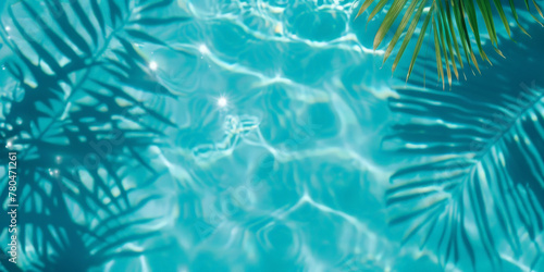 A closeup of  blue water swimming pool with palm leaves  shadows . creating a beautiful summer scene. banner
