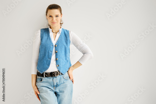 Stylish woman in denim vest and jeans