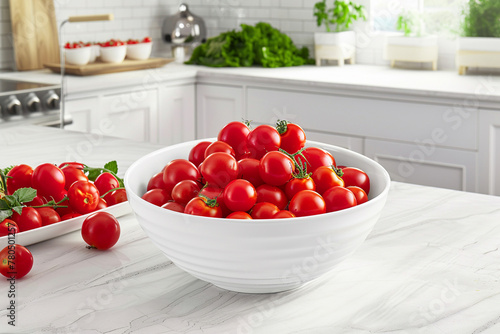 White bowl with fresh organic cherry tomatoes on a table in a bright kitchen. Healthy eating concept.