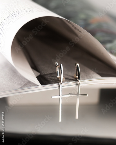 silver earrings crosses on the background of the magazine