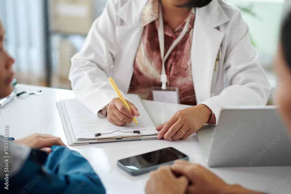 Pediatrician talking to patient and filling medical history Pediatrician talking to patient and filling medical history