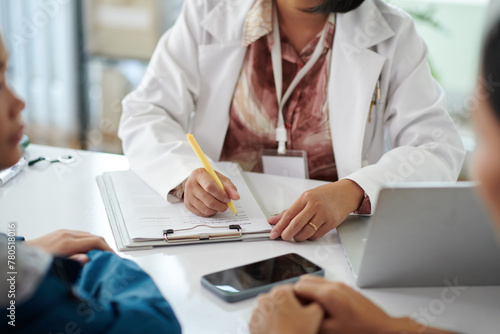 Pediatrician talking to patient and filling medical history