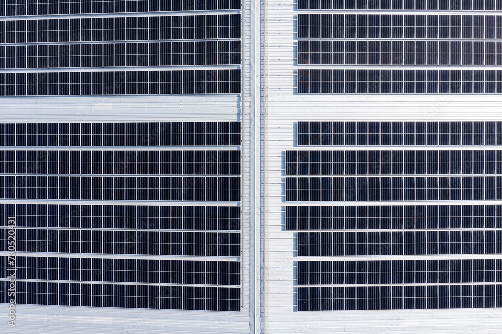 Solar panels on a roof of a large industrial or warehouse building, aerial view form top. Solar panels on a roof of a large industrial or warehouse building, aerial view form top.