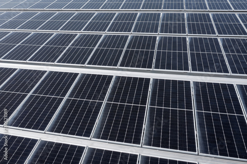 Solar panels on a roof of a large industrial or warehouse building  aerial view form top.