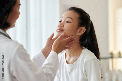 Dermatologist examining face skin of teenage girl © DragonImages