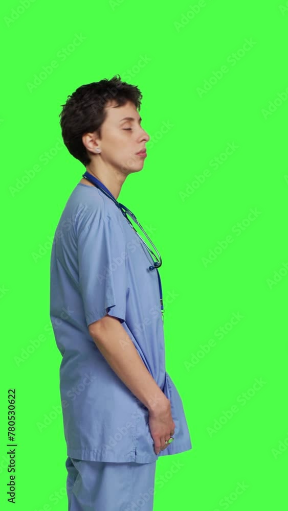 Profile Displeased nurse saying no and sighing against greenscreen backdrop, acting disappointed while she wears blue scrubs. Medical assistant with expertise shows negative gesture, being tired Profile Displeased nurse saying no and sighing against greenscreen backdrop, acting disappointed while she wears blue scrubs. Medical assistant with expertise shows negative gesture, being tired