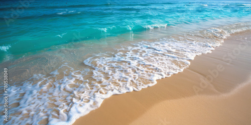 A tranquil beach scene featuring soft white waves lapping on a sandy shore against a clear blue sky