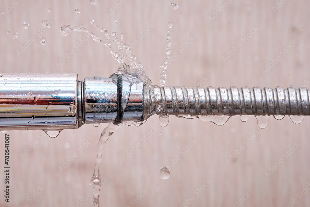 Laaking water hose close to shower head, water flow from the hole of