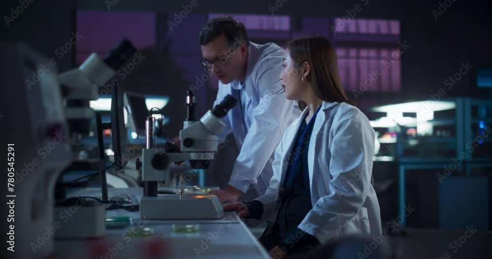 Asian Female Medical Project Manager Having a Conversation with a Scientist About a Gene Editing Research, Crispr Technology and Experiments. Smart Diverse Team Working in a Laboratory at Night Asian Female Medical Project Manager Having a Conversation with a Scientist About a Gene Editing Research, Crispr Technology and Experiments. Smart Diverse Team Working in a Laboratory at Night