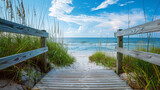 Wooden bridge leading to a serene beach on a clear sunny day with blue skies and fluffy clouds