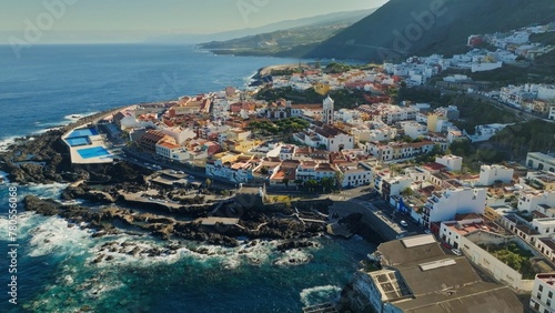 Aerial view of old town of Garachico on island of Tenerife, Canary. Flying over Garachico city center with colored houses. Ocean shore and lava pools. Popular tourist destination, Canary Islands © SJ Travel Footage