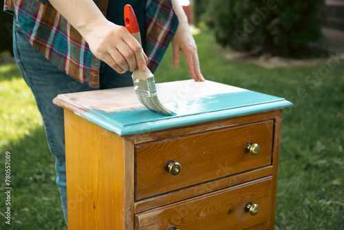 Obraz na plátne Painting a wooden furniture outdoors, an eco-friendly re-use business