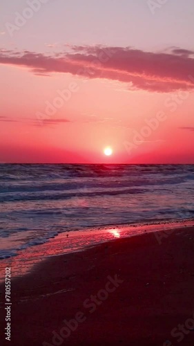 Beautiful scenery of the sea beach at sunset. The evening sky is reflected on the wet sand. Sunset on the sea waves. Beautiful sunrise over a tropical beach. Evening twilight on the beach. Vertical fo