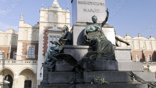 Camera tilts up the Adam Mickiewicz Monument in Rynek Glowny, Main Square in Krakow photo