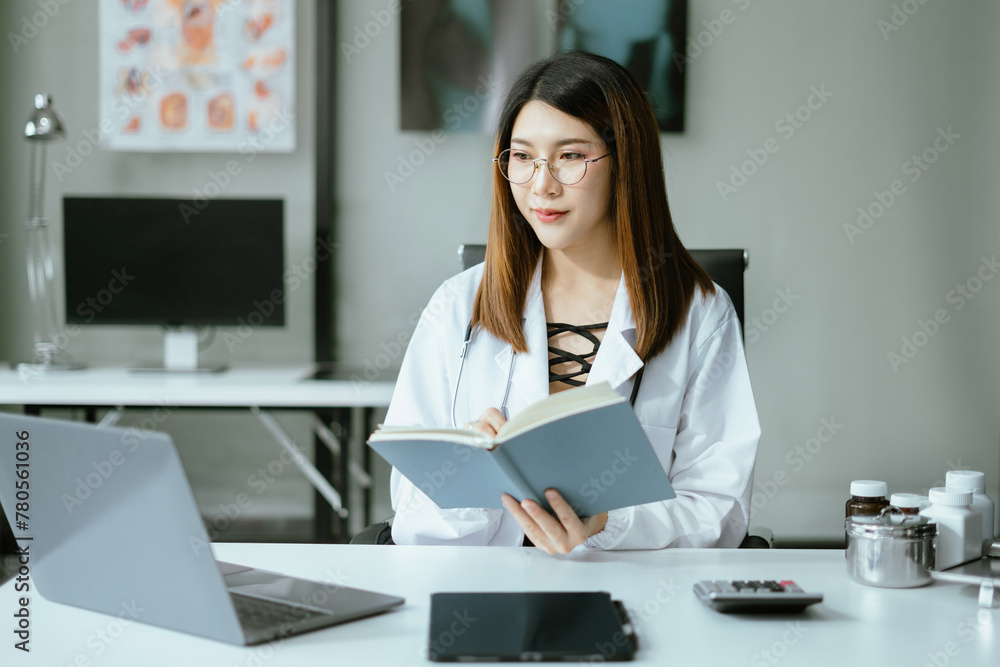 Female medicine doctor, physician or practitioner in lab room writing on blank notebook and work on laptop computer with medical stethoscope on the desk at hospital. Medic tech concept. Female medicine doctor, physician or practitioner in lab room writing on blank notebook and work on laptop computer with medical stethoscope on the desk at hospital. Medic tech concept.