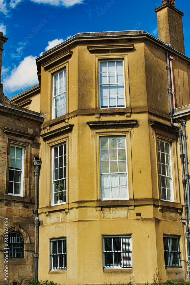 Fototapeta premium Classic European architecture with a clear blue sky. The building features a warm beige facade, large windows, and traditional stonework details in York, North Yorkshire, England.