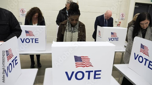 4K: Black Female Voting at Polling Place for the USA Presidential Election. 25-29 years. People Stood around her. Gimbal around. Stock Video Clip Footage