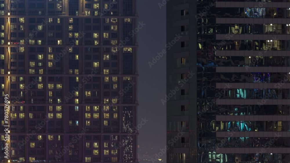 Tall blocks of flats with many glowing windows located in residential district of city aerial timelapse. Evening light in rooms in big towers and skyscrapers Tall blocks of flats with many glowing windows located in residential district of city aerial timelapse. Evening light in rooms in big towers and skyscrapers