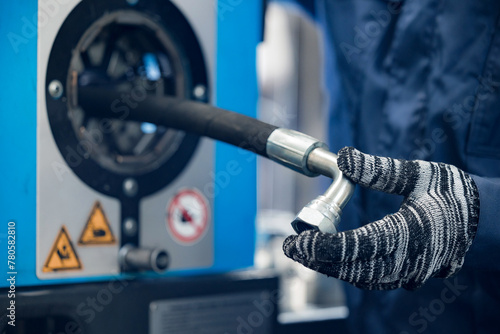 Tableau sur toile Manufacturing process Worker crimps pressure hydraulic hose with fitting on mach
