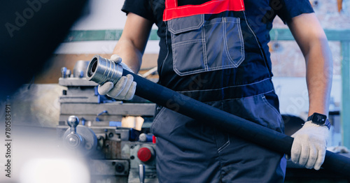 Industrial worker with hydraulic hoses with fitting connection pipe, heavy industry banner photo