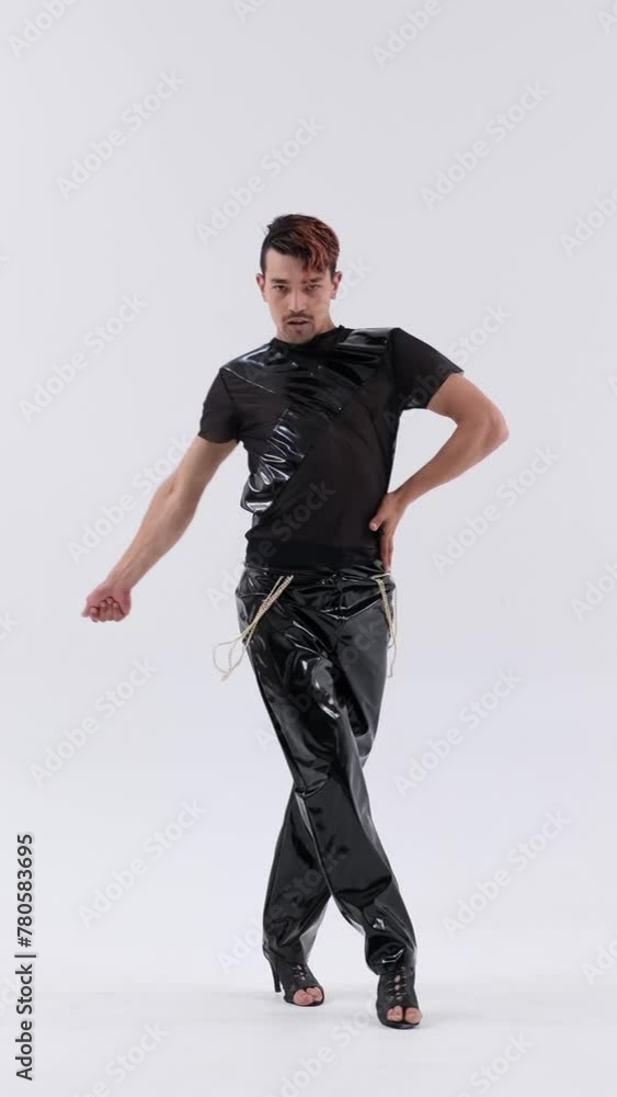 Talented and energetic Caucasian man dancer performing dynamic contemporary or vogue dance on high heels on white background. Vertical video. Talented and energetic Caucasian man dancer performing dynamic contemporary or vogue dance on high heels on white background. Vertical video.